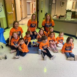 Preschoolers after the fun run sitting on the floor